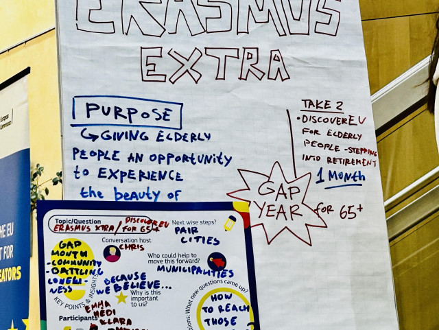 A flip chart from an open space workshop 
Text: 
Erasmus Extra 
Purpose: giving elderly people the opportunity to experience the beauty of Europeannnes 
Take 2: discover EU for elderly people stepping into retirement 
1 month gap year for 65+

