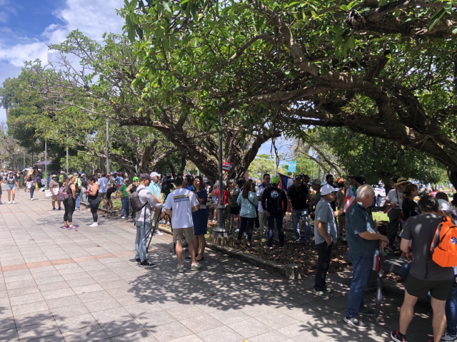 Puerto Rican community preparing to march through old San Juan. People wave signs and Puerto Rican flags