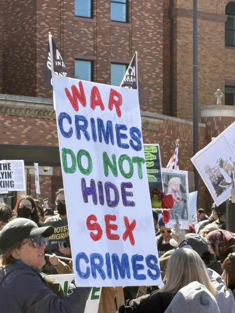 Protest sign seen at No Kings 3/28/26: War crimes do not hide sex crimes