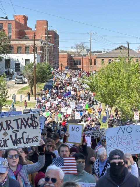 Long street full of marching protestors. 