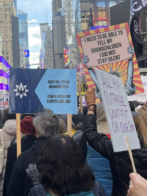 Within a protest march down 7th Avenue of NYC on a cold, sunny afternoon. Signs: “Visiting from Minneapolis, thank you for supporting us!”; “I need to be able to tell my grandchildren I did not stay silent”; “All my outrage won’t fit on one sign”