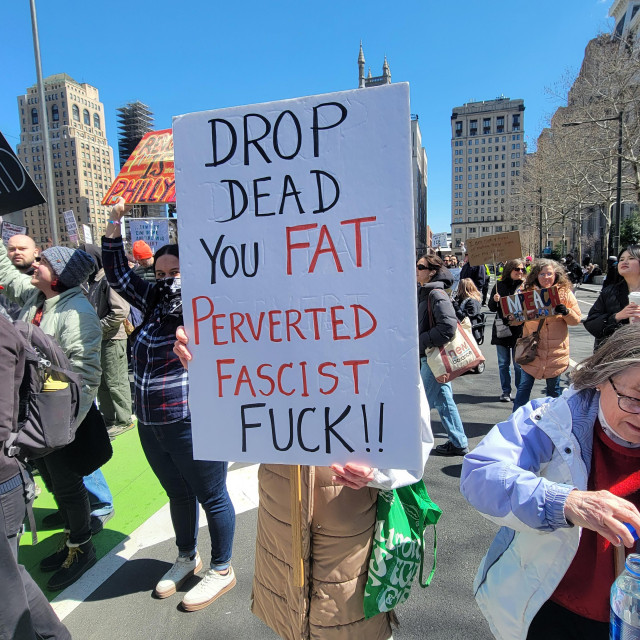 A sign seen at the No Kings rally in Philadelphia that says: "DROP DEAD YOU FAT PERVERTED FASCIST FUCK!!"