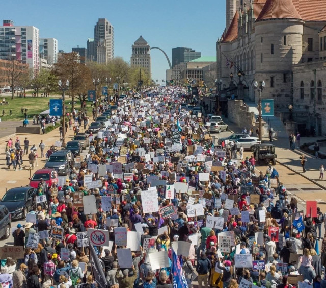 Thousands of people march down Market Street in downtown St. Louis for No Kings Day.