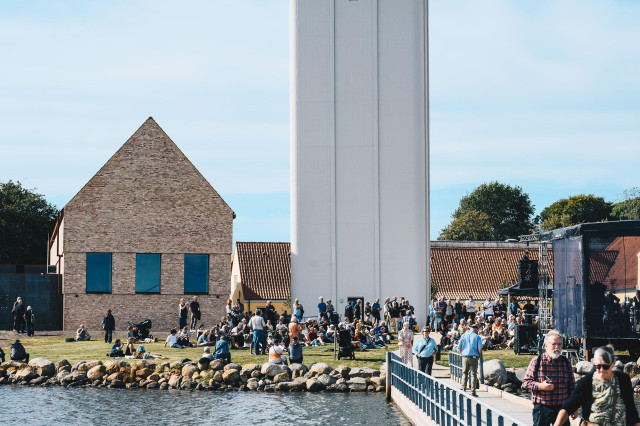 To bygninger ved vandkanten på en sommerdag. 