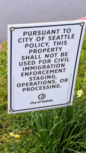 A sign in a city park that reads "pursuant to city of Seattle policy, this property shall not be used for civil immigration enforcement staging, operations, or processing. —City of Seattle