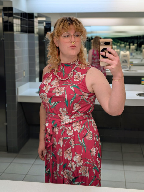 A mirror selfie of a white trans woman