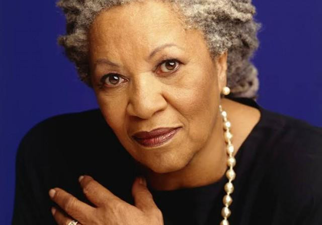 Toni Morrison in the 1980s. She is a black woman with greying locs that have been tied back.
