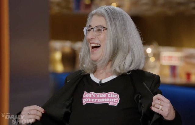 EFF's Cindy Cohn displaying her "Let's Sue the Government" shirt on The Daily Show