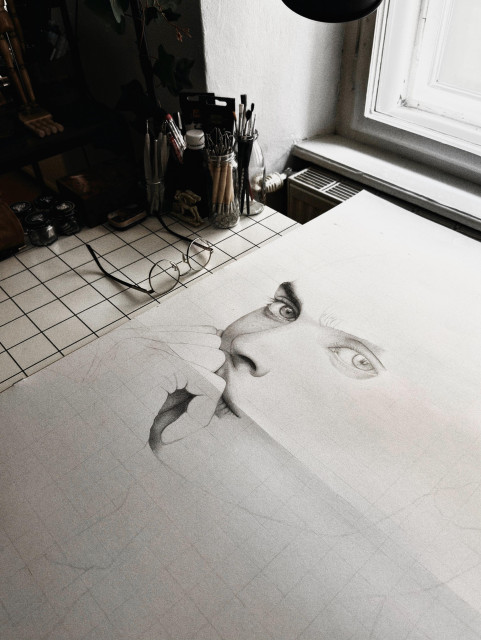 A photo of an unfinished pencil drawing, depicting a portrait of a woman.
