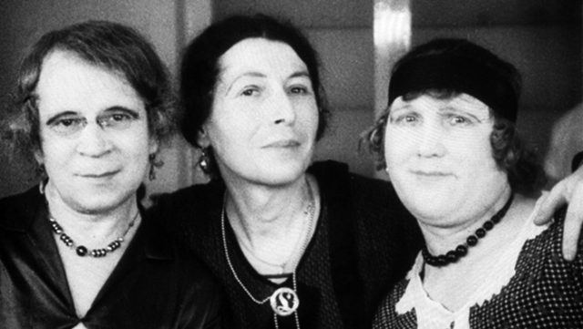 3 women hugging and looking to the front. Only portraits, head and sholders visible. Black and white photo