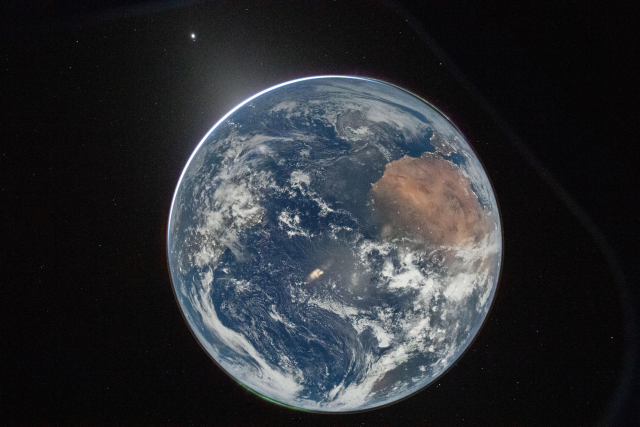 Description from NASA on X - A full disk image of Earth, as seen from the Orion capsule. The planet is a pale blue, swirling with white clouds and glowing slightly lighter blue in place from reflected light. From about 2 to 3 o'clock, a large brown landmass is Africa, with the Iberian peninsula twinkling with lights just where the planet curves. At the 7 o'clock spot, aurora glow in a thin green glow, just barely separated from the planet's surface. Earth is set against the black of space. Credit: NASA/Reid Weisman

This image is rotated by 180 degrees from the original posted image