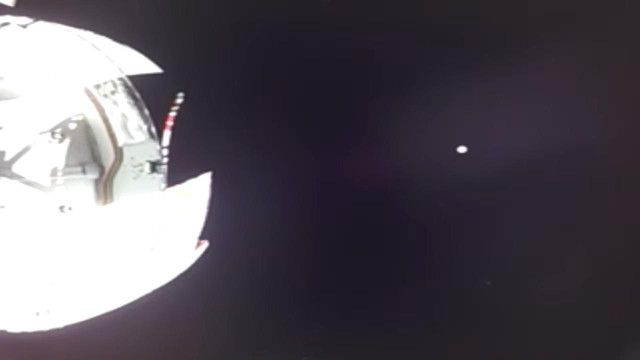 Pic from Orion with over exposed image of the spacecraft body and a tiny earth in the distance