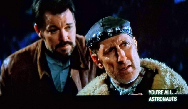 Star Trek First Contact scene, and if you haven't watched this one you should cancel all plans and view immejietly. (Also has a Mark S from Severance cameo) Ok, it's nighttime and we're close in on 2 dudes, closest is Zefram Cochrane, and just behind him is William T. Riker, famous tromboner. Both are in civilian clothes, Riker a leather jacket, and Zefram in a bomber type coat with the white fluffy wooly stuffing around the collar. Zefram is also wearing a weird black hat that is sort of like a bandana in form and function, but instead of fabric it's bedazzled leather. He's speaking, and looks kind of dumbfounded or stumped. Closed caption reads, "You're all....astronauts .. on some kind of Star Trek"

Happy First Contact Day 🖖🏼