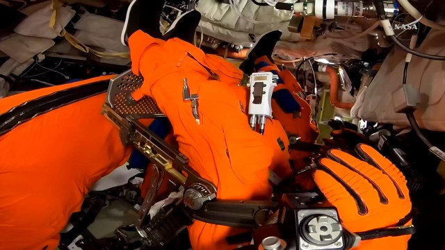 Pic from inside Orion with a jumble of orange suited torsos, shoes and gloves.