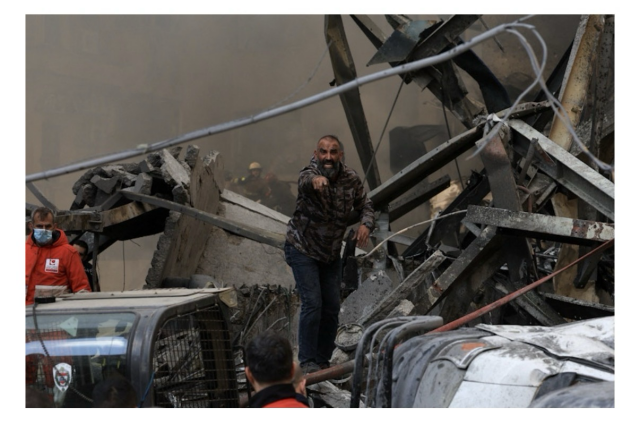 A man in rubble after an Israeli attack yells for assistance REUTERS/Mohamed Azakir
