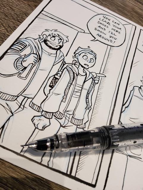 Photo of a Dead City page on a table with a fountain pen overtop of the page.