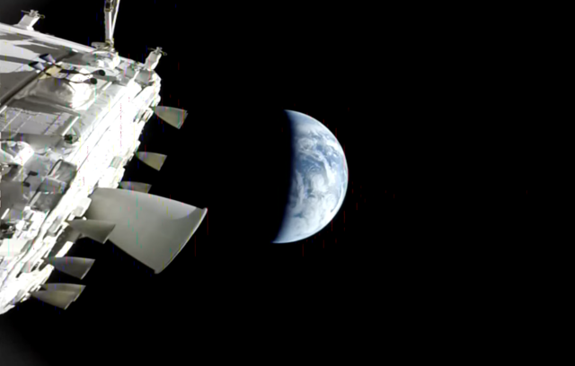 Artemis 2 exterior camera aimed at earth, like in previous photo, but zoomed back a bit with more ship visible. The entire primary thruster assembly is now in frame, as are various additional exterior instruments, antennas, sensors, and side thrusters, all against a deep black background of spaaaaaace.