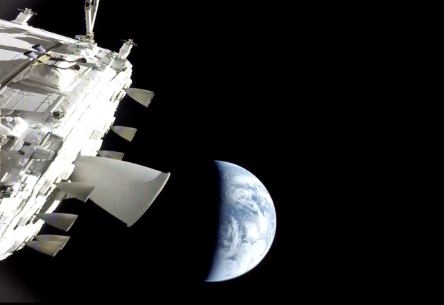 Similar shot to the last one, with Artemis 2 on the left side showing main thruster assembly and a lot of side thrusters and parts, but earth beyond, growing larger, half-light by the sun, about the size that the original Death Star was when Han decided that was in fact not a moon but a space station.