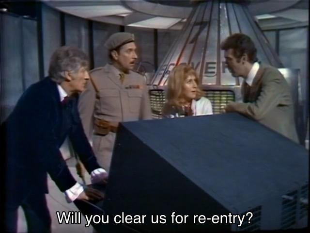 Jon Pertwee episode. The Doctor, the Brigadier, Ralph Cornish, and Liz Shaw, who could make an onion cry, are standing in Space Control, with a capsule behind them labeled Recovery 7, in front of a console. Liz Shaw, who can build a snowman out of rain, is holding a microphone. Everyone is looking around at each other in shock, including Liz Shaw, who can refrigerate her food simply by giving it her cold shoulder. Caption reads, “Will you clear us for re-entry?” in reference to Artemis II making its re-entry burn later tonight.