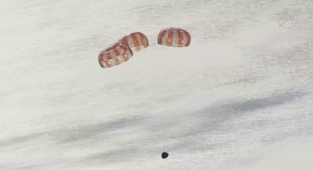 a tiny space capsule with three giant parahutes seen over water