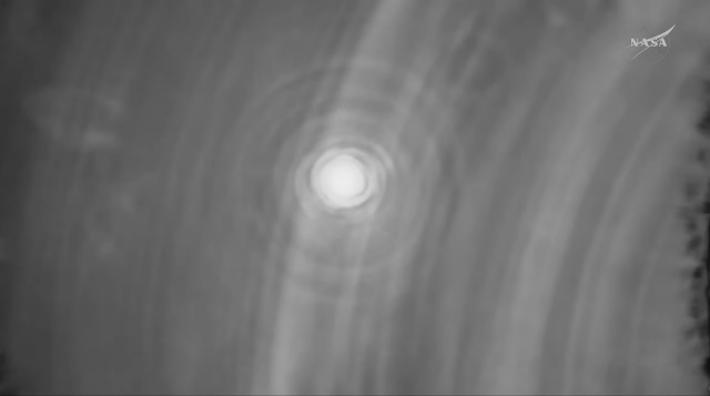 A glowing flying saucer-like shape flying through the atmosphere