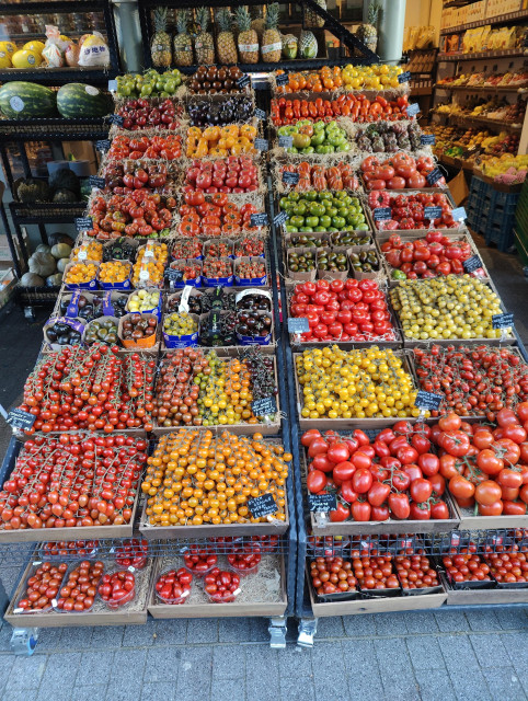 A greengrocer's display of tomatoes. I have counted at least 36 different varieties with red, orange, yellow, green, black and purple colours and all sorts of different sizes.