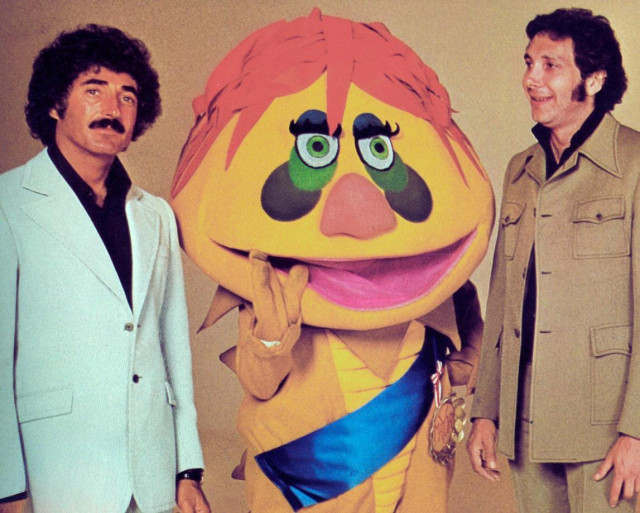 Sid Krofft (1929-2026) left and Marty Krofft (1937-2023) right, flanking their creation H.R. Pufnstuf. 
