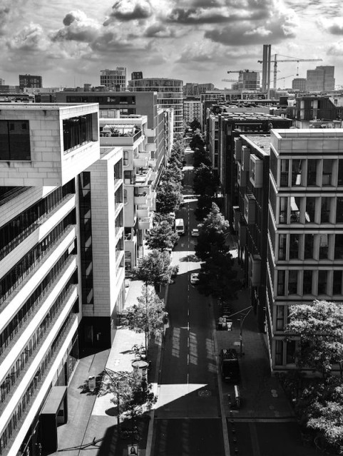 Blick von der Elbphilharmonie runter auf einen Strassenschlucht in Hamburg. Das Foto ist in Schwarzweiß.