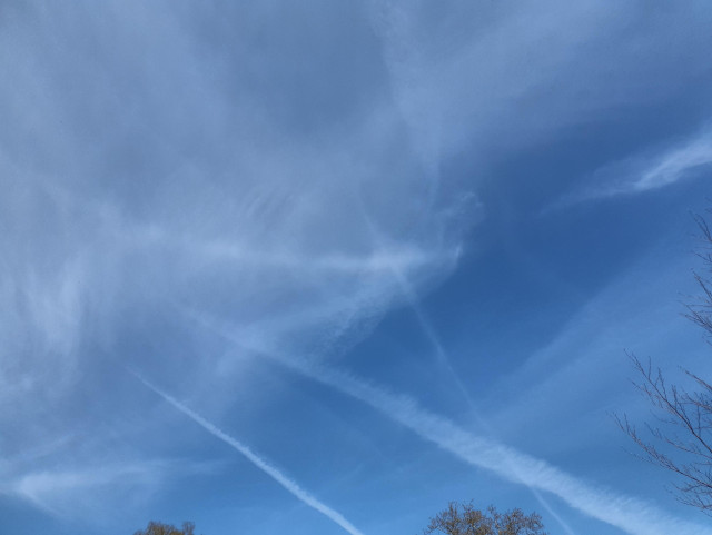 Foto dea Himmels mit Cirruswolken. In den Wolken ein heller, farbloser Streifen als Ring parallel zum Horizont. In diesem an einer Stelle eine Verdickung.