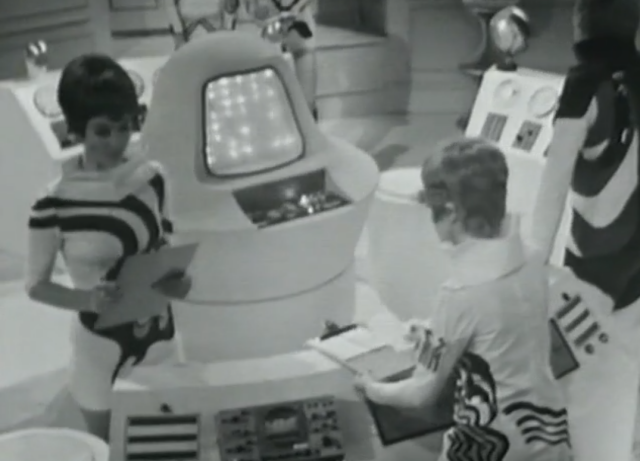 A control room with four people. Each has a unique costume of swirls.