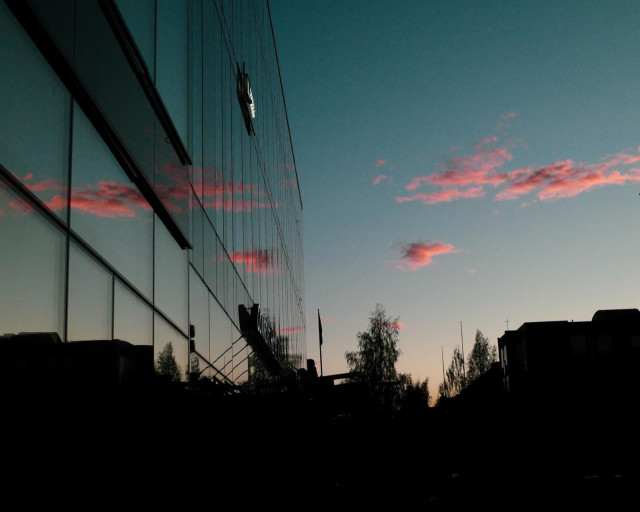 Pink clouds reflecting in glass facade