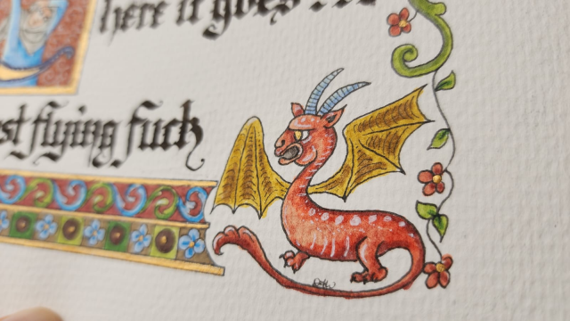 Close up on the little dragon critter. It has a red body with spots along its back and a striped belly, gold-yellow wings, blue horns, and a long tail.