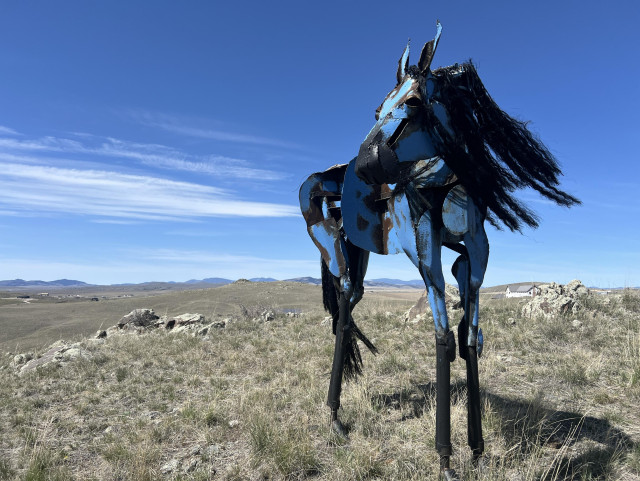 A single horse sculpture, looking over its shoulder to the left