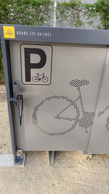 Grey bicycle locker closed and locked with a folding lock