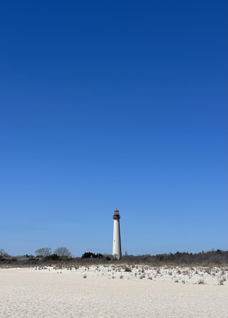 Cape May lighthouse , sandy beach in front.