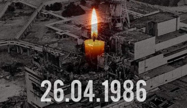A lit candle burns in the foreground against a black-and-white image of the damaged Chernobyl reactor, with the date “26.04.1986” overlaid below.