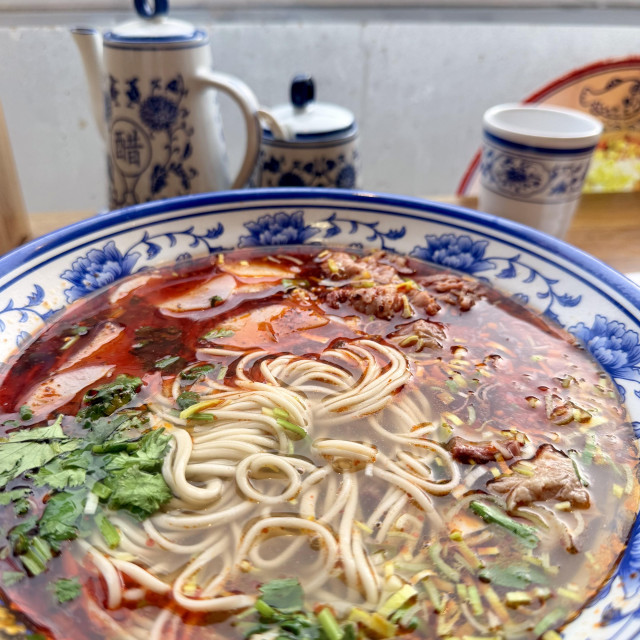 A photo of Lanzhou noodles (hand pulled beef noodles) with lots of chilli in it 