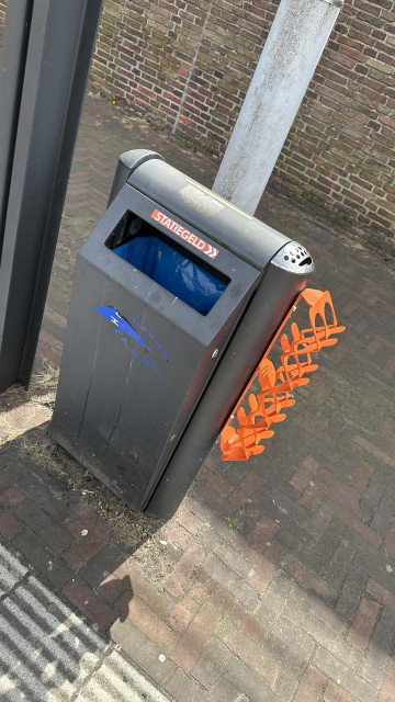 Trash bin with a holder for empty cans 