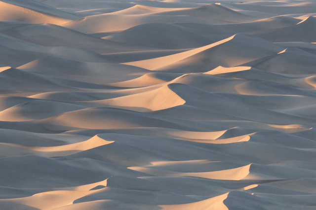 Repeating sand dunes at sunset. 