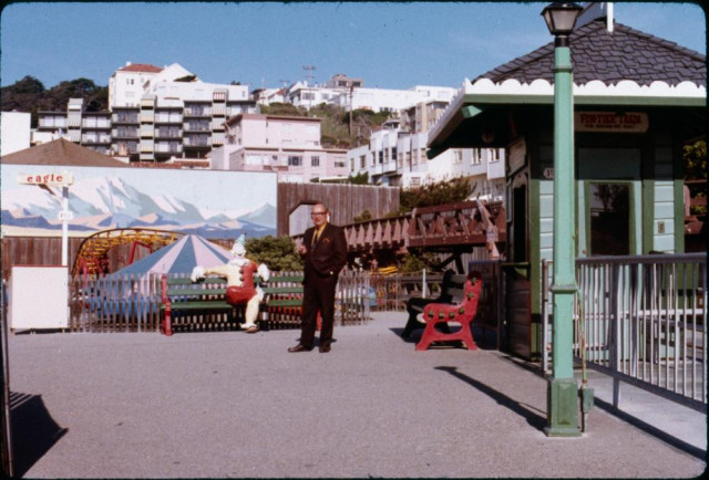 Fun Tier Town, circa 1968
A man in a suit posed near a seated clown figure on a bench. The clown looks pretty bright and colorful