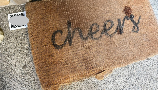 my door mat with a 3d printed qr code to the side, the qr code is covered up in this picture to protect the integrity of the experiment