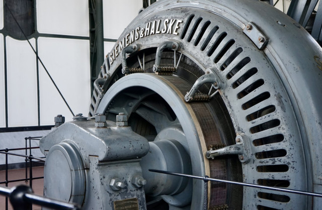 Gros plan sur une grosse machine d’extraction Siemens & Halske gris-bleu vue de trois quarts.