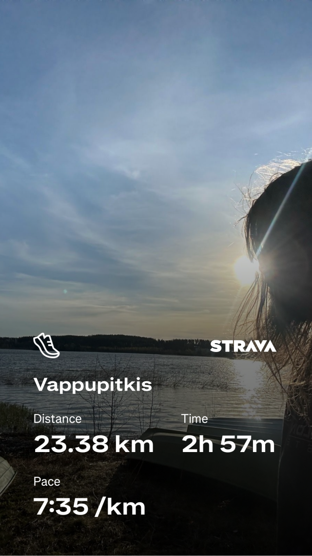 Sunset by the water with fitness stats overlay: 23.38 km, 2h 57m, pace 7:35/km. Person on right silhouette with sunlight.