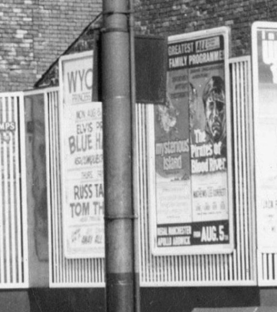 b/w street photo including film poster for: Blue Hawaii / Tom Thumb / Mysterious Island / The Pirates of Blood River  (close up)