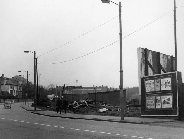 b/w street photo including film poster for: ? / Genevieve / Witchfinder General / Doctor Faustus