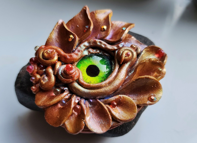 A red-orange dragon eye with a bright green iris