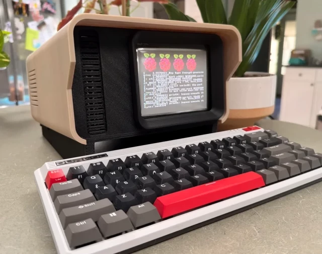 A cyberdeck desk terminal of sorts, featuring a beige enclosure with a black face. There is a small CRT embedded in the main unit, and a separate mechanical keyboard in the foreground. 