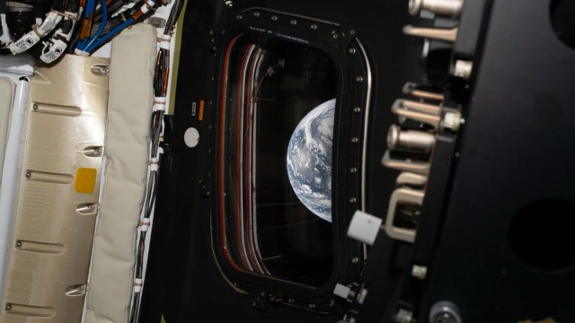 The Earth seen through a window in the Orion module during the Artemis II mission