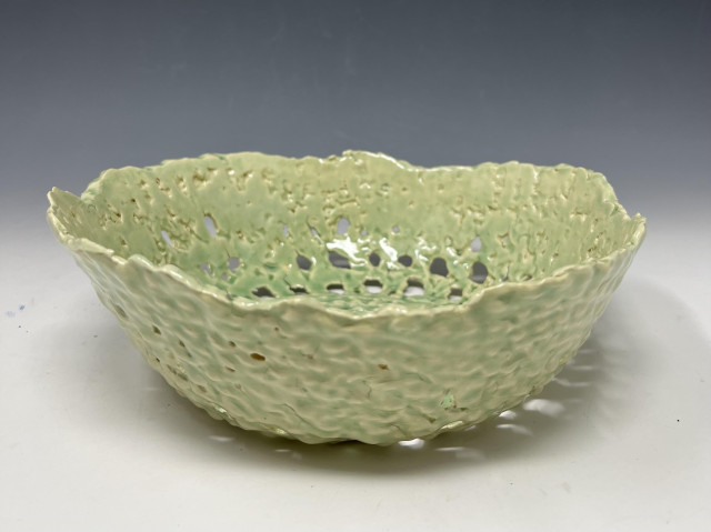 Side-view of a bowl made from a round crocheted fabric, soaked in Laguna's B-Mix slip, then placed on a slump mold until it was stiff enough to remove. After bisque firing (at this stage the piece is super fragile), I mouth-sprayed several layers of Korean Celadon glaze. It's in one piece -- so that's something. 