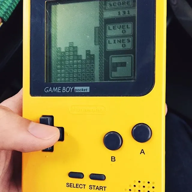 A yellow game boy, showing the game Tetris being played, with a score of 131